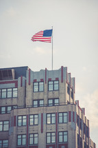 American flag at the top of a tall building 