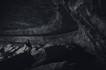 woman squatting in a cave 