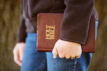 woman carrying a Bible at her side