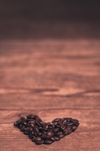 heart shaped coffee beans on wood background 