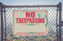 No Trespassing sign on a chain linked fence 