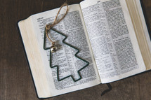 green Christmas tree ornament on the pages of a Bible 