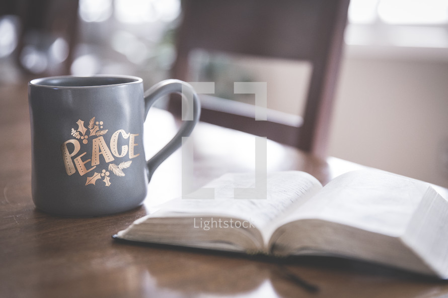 open Bible on a table and coffee mug at Christmas 