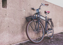 a bicycle leaning against a concrete wall 