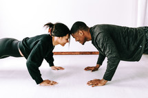 a couple doing push-ups together 
