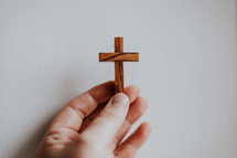 hand holding a wooden cross