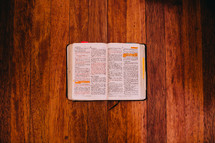 Open Bible on a  wood floor.