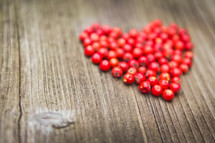 red heart of berries on a wood background 