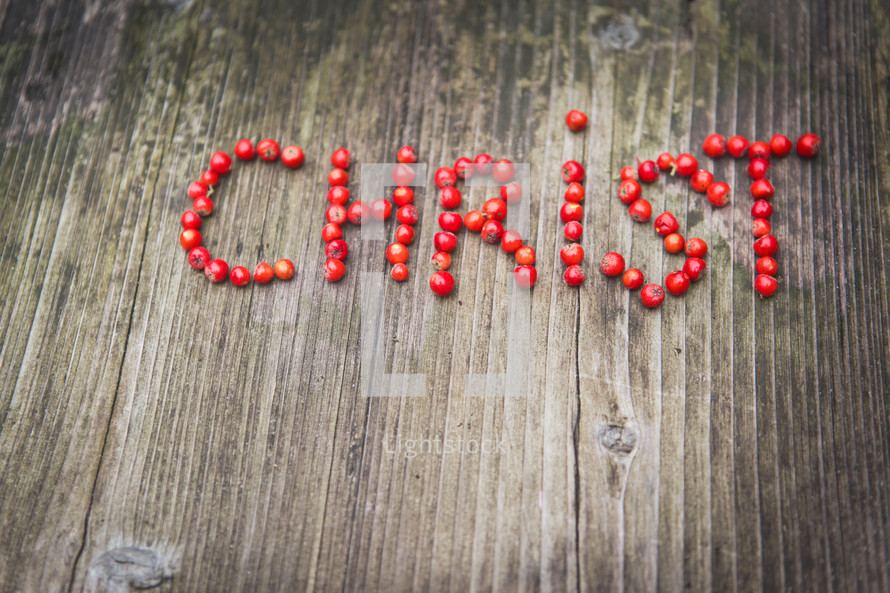 word Christ in red berries on a wood background 