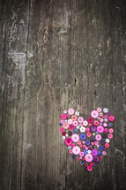 heart in buttons on a wood background 