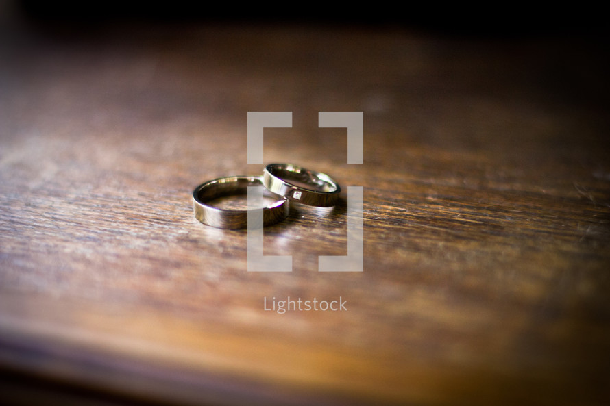 Wedding bands on a wooden table.
