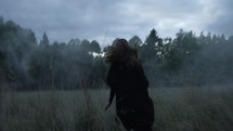 a woman running through a foggy field 