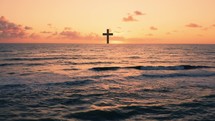 Silhouette of Christian cross in the ocean at sunset