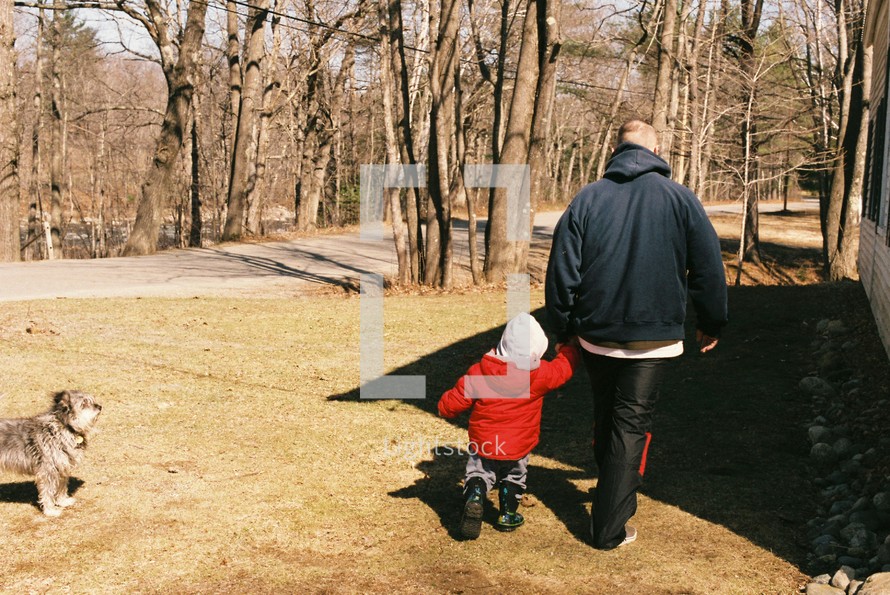 a father walking with his son outdoors 