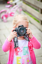 a girl child taking a picture with a camera 