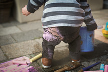a toddler with sidewalk chalk