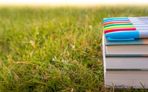 sharpies on a stack of books in the grass