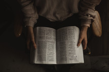 a woman reading a Bible alone at home 