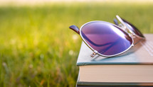 sunglasses on a stack of books 