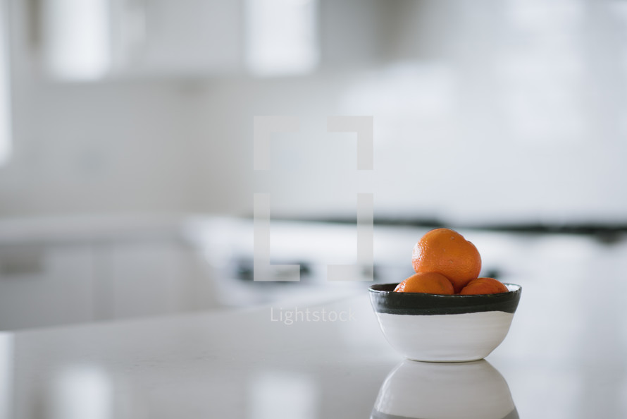bowl of oranges in a kitchen 