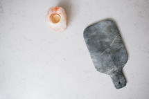 salt lamp, candle, cutting board on a kitchen countertop 