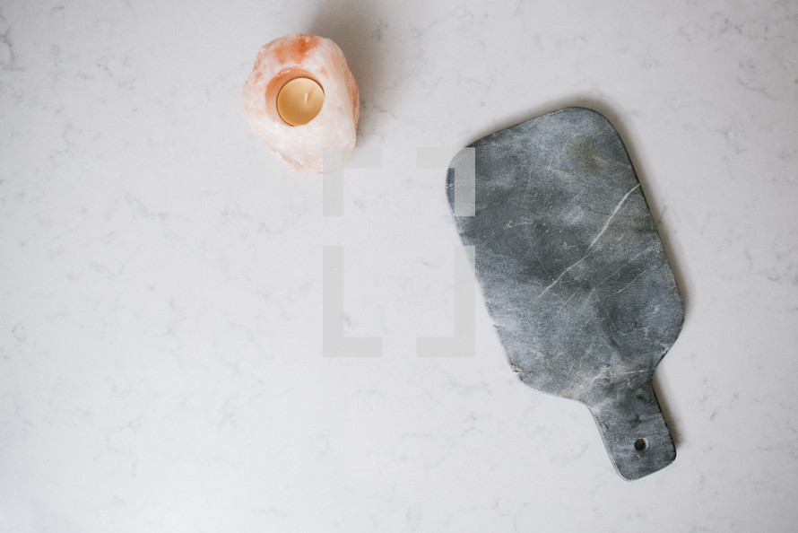 salt lamp, candle, cutting board on a kitchen countertop 