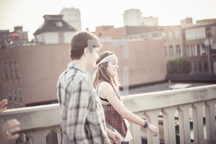 Teen couple on a roof balcony.