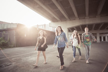 Teens walking  under an overpass.