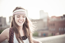 A young woman laughing on the roof of a building