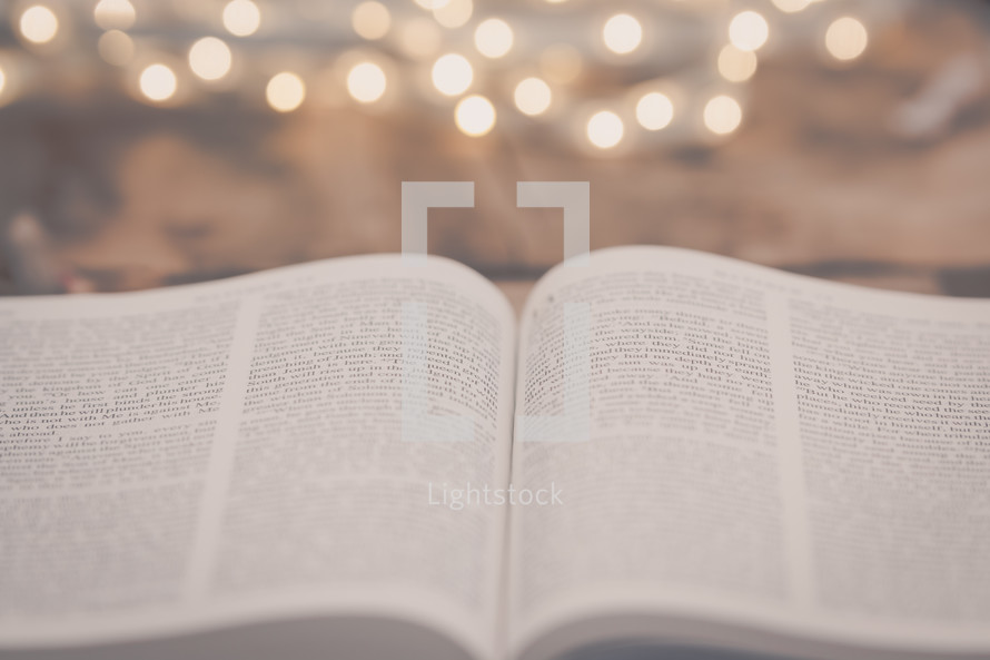 open pages of a Bible and bokeh lights 