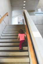 a toddler girl walking up stairs 