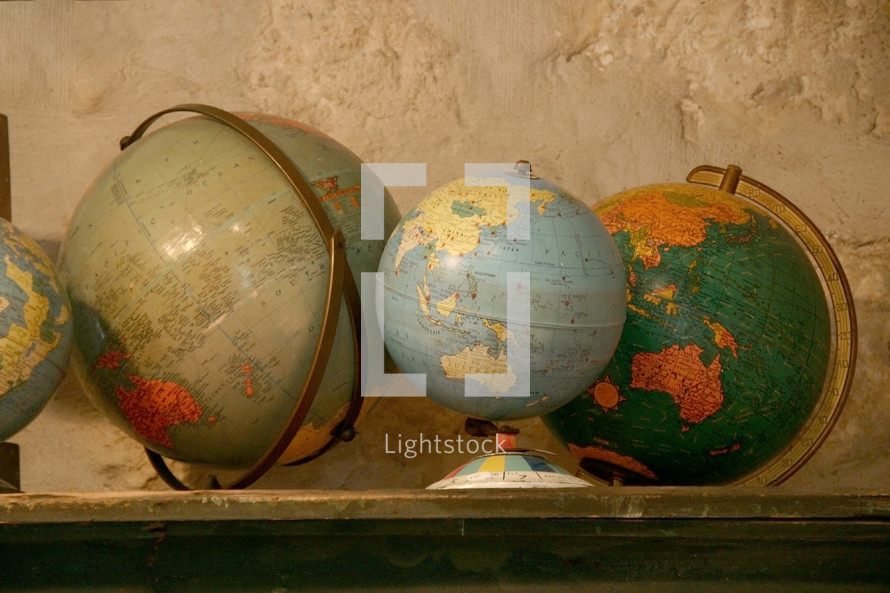 row of vintage globes on a shelf 