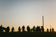 silhouette of a crowd of people walking outdoors 