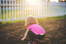 a girl playing in dirt 