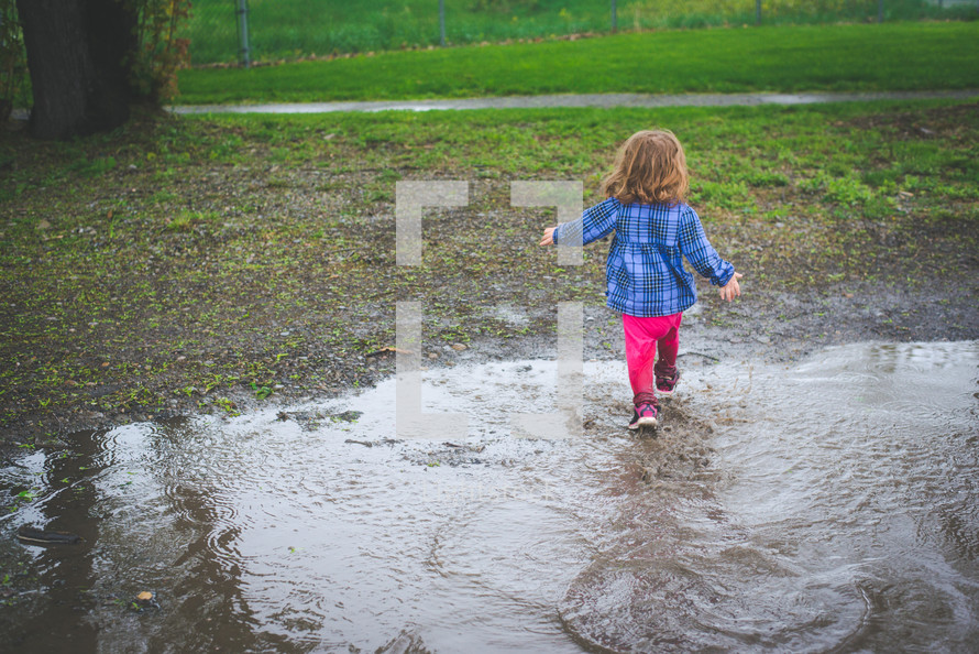 a girl running through puddles 