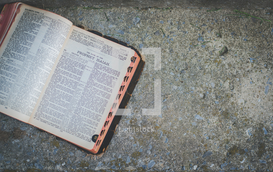 open Bible on a sidewalk 