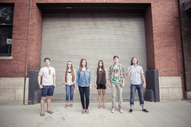 teens standing in front of a garage 