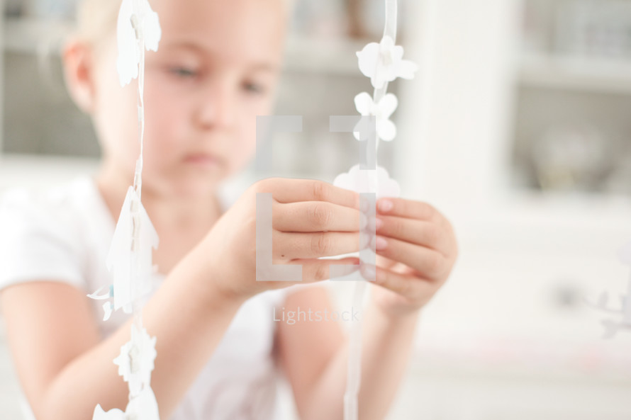 a girl child making paper ornaments 