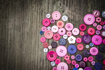 heart of buttons on a wood background 