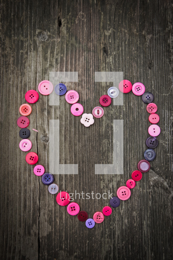heart of buttons on a wood background 
