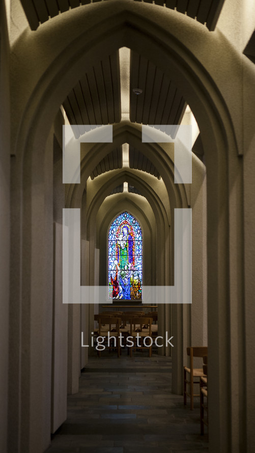 wooden chairs in a church and stained glass window 