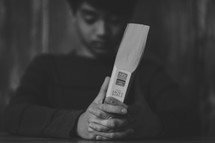 young man praying holding a Bible 