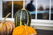 gourds and pumpkins near a window 