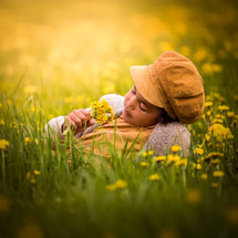 a child holding picked flowers in a field 