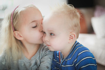 a big sister kissing her baby brother 