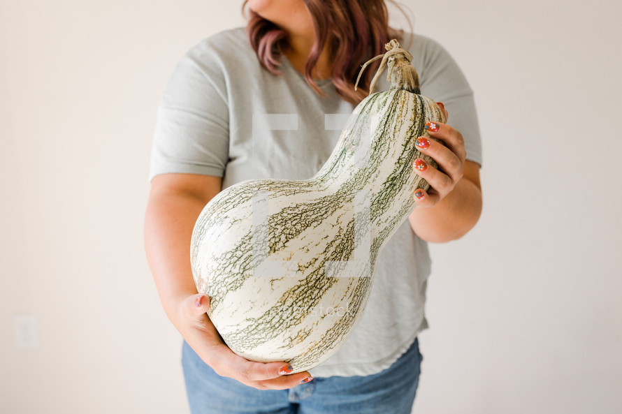 a woman holding a large gourd 