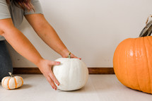 a woman decorating with pumpkins 