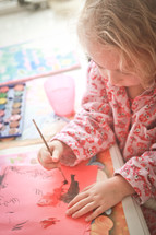 A little girl painting with water colors.