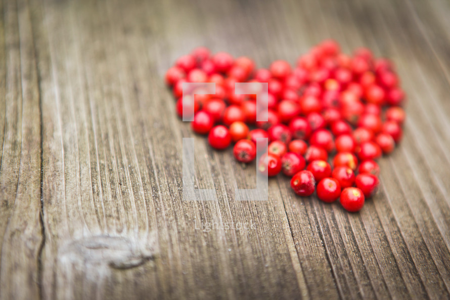 red heart of berries on a wood background 