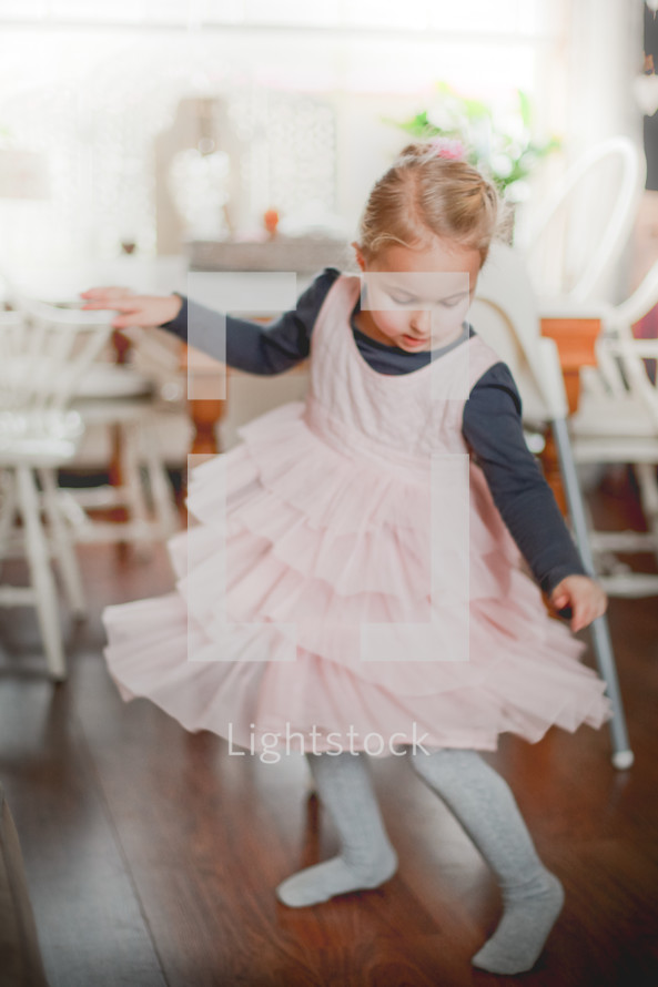 a girl child dancing in a dress 